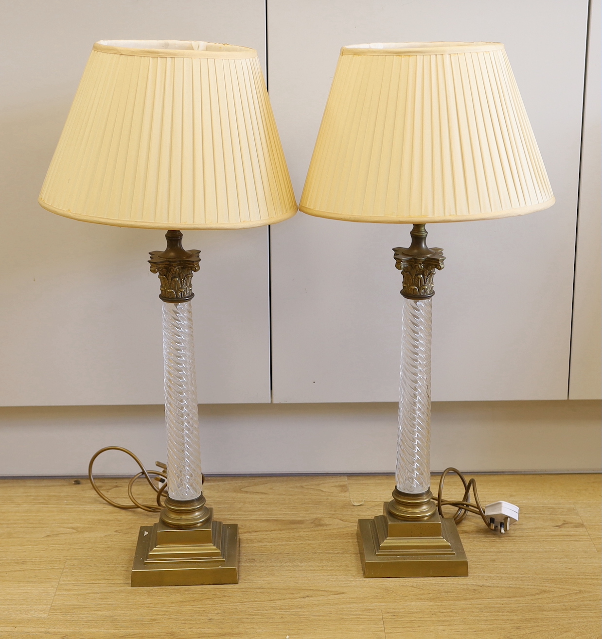 A pair of brass and glass Corinthian column table lamps, 52cm high not including light fitting